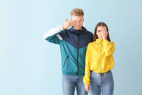 Young couple in stylish sportswear on color background — Stock Photo, Image