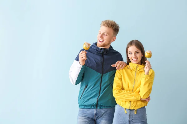 Młoda para w stylowej odzieży sportowej na kolorowym tle — Zdjęcie stockowe