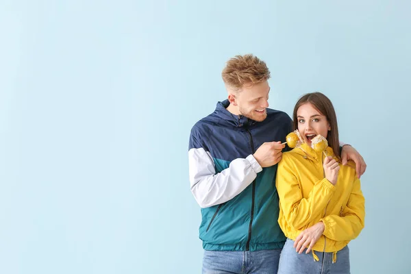 Pareja joven en ropa deportiva con estilo sobre fondo de color — Foto de Stock