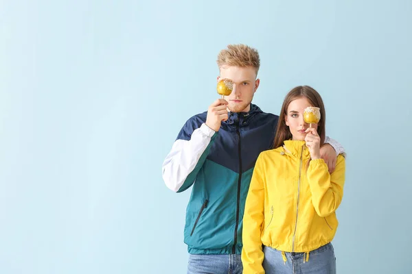 Young couple in stylish sportswear on color background — Stock Photo, Image