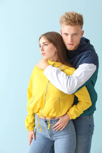 Giovane coppia in elegante abbigliamento sportivo su sfondo di colore — Foto Stock