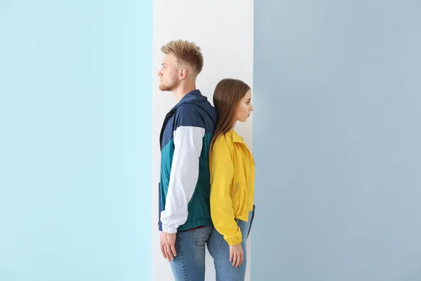 Pareja joven en ropa deportiva con estilo sobre fondo de color — Foto de Stock