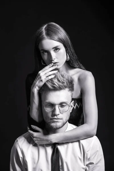 Black and white portrait of fashionable young couple on dark background — Stock Photo, Image