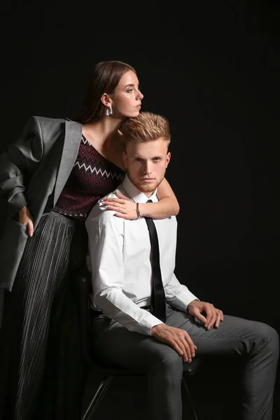 Retrato de jovem casal na moda no fundo escuro — Fotografia de Stock