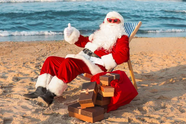 Happy Santa Claus with gifts at sea resort — Stock Photo, Image