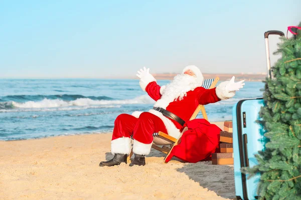 Щасливий Дід Мороз з подарунками відпочиває на морському курорті — стокове фото