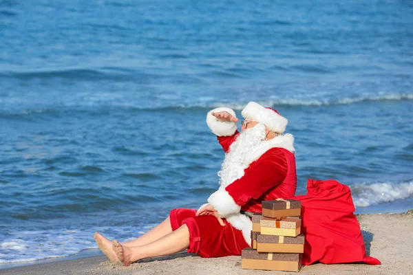 Santa Claus with gifts at sea resort — Stock Photo, Image