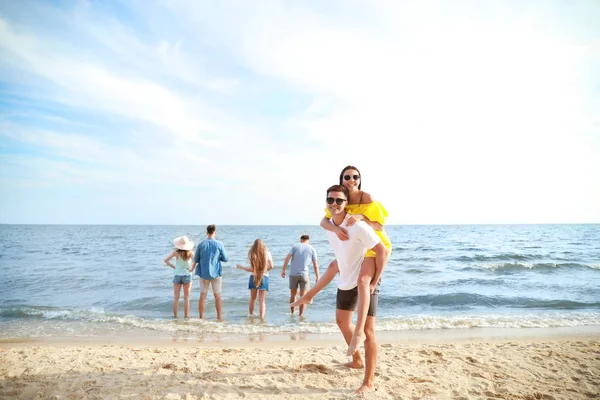 Felices amigos en la playa del mar en el resort — Foto de Stock