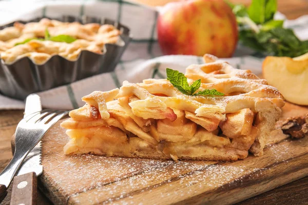 Piece of tasty apple pie on board, closeup