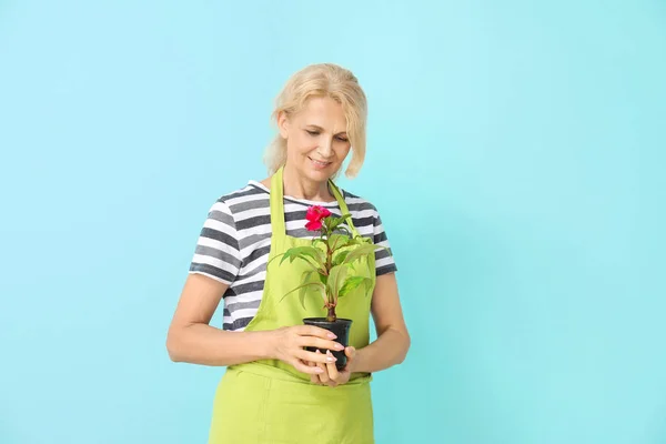 Portrait of female gardener on color background — Stock Photo, Image