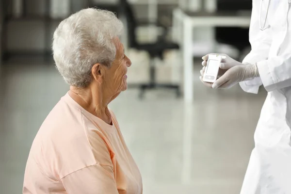 Medico controllando i livelli di zucchero nel sangue della donna diabetica a casa — Foto Stock