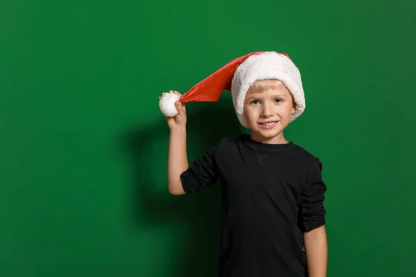 Petit garçon mignon dans le chapeau du Père Noël sur fond de couleur — Photo