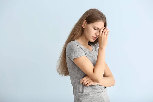 Stressed young woman on color background