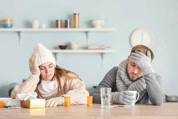 Sjukt par sittande vid köksbordet — Stockfoto