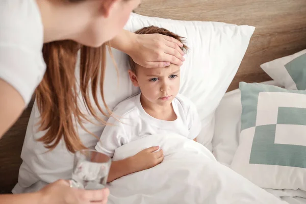 Мати доглядає за своїм маленьким сином, хворим на грип вдома — стокове фото