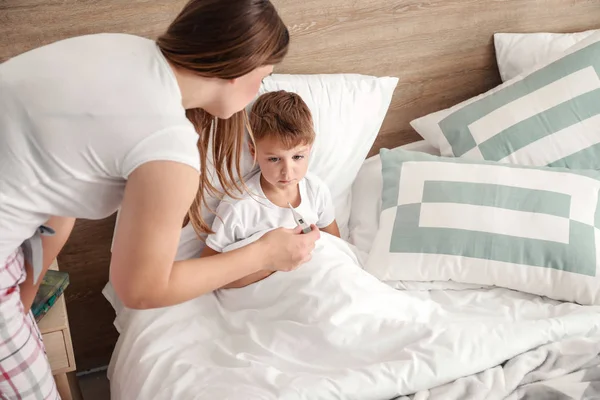 Moeder meettemperatuur van haar kleine zoon ziek met griep thuis — Stockfoto