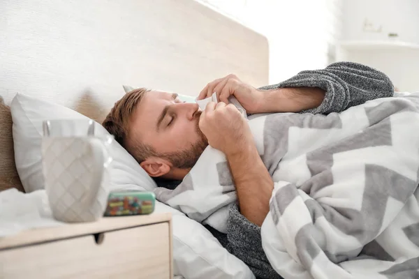 Man ill with flu lying in bed — Stock Photo, Image