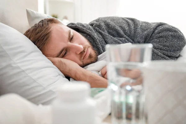 Hombre enfermo de gripe acostado en la cama — Foto de Stock