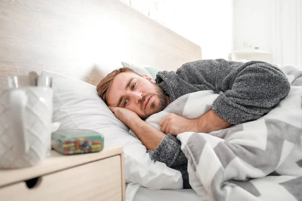 Homem doente com gripe deitado na cama — Fotografia de Stock