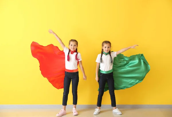 Renkli duvara yakın süper kahraman lar gibi giyinmiş ikiz kızların portresi — Stok fotoğraf