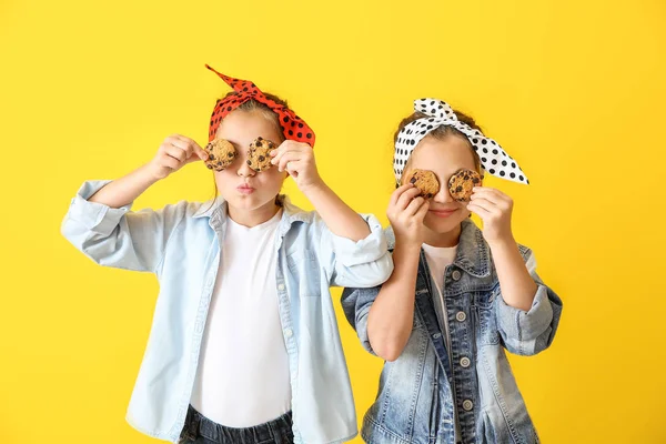 Ritratto di ragazze gemelle felici con biscotti sullo sfondo a colori — Foto Stock