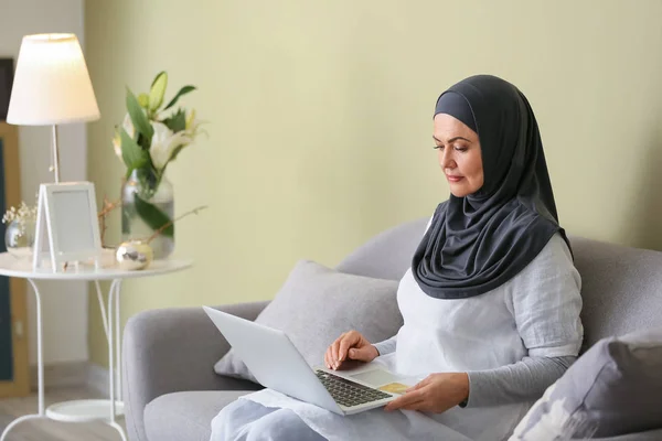 Gyönyörű érett muszlim nő laptopon otthon — Stock Fotó
