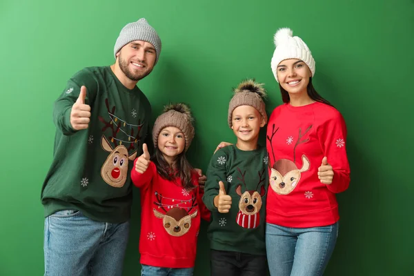 Щаслива сім'я в різдвяних светрах на кольоровому фоні — стокове фото