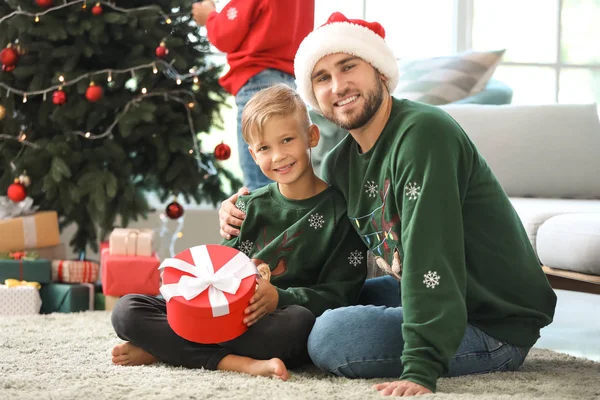 Happy father and son with gift at home on Christmas eve