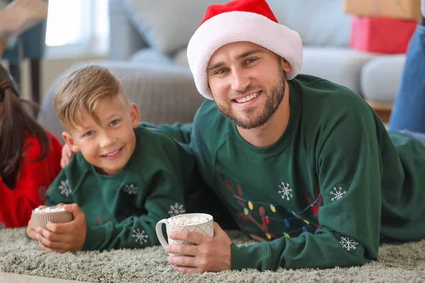 Happy family drinking hot chocolate at home on Christmas eve