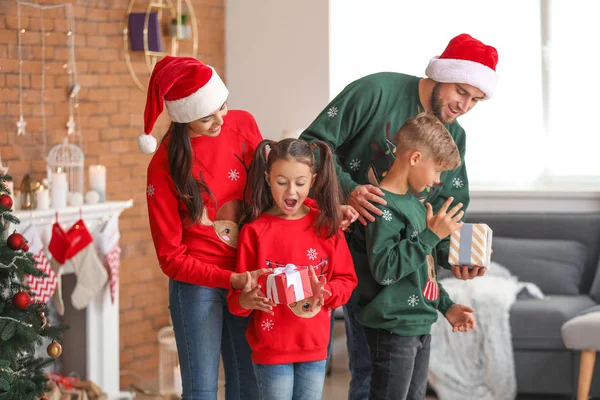 Счастливая семья с подарками дома в канун Рождества — стоковое фото