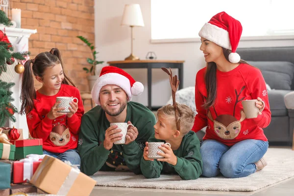 Happy family drinking hot chocolate at home on Christmas eve