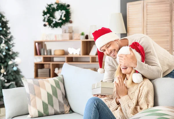 Man greeting his wife at home on Christmas eve — Stock Photo, Image