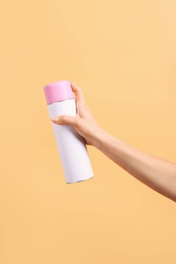 Renkli arka planda hava spreyi şişesi ile kadın el