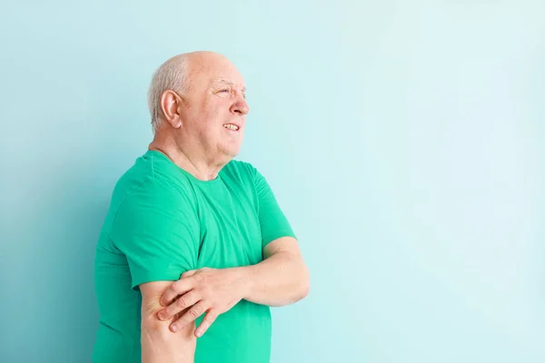 Senior man suffering from pain in elbow on light background — Stock Photo, Image