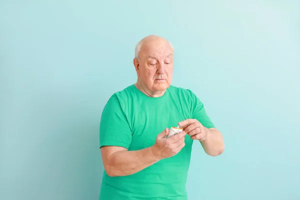 Diabetic man with digital glucometer on light background — Stock Photo, Image