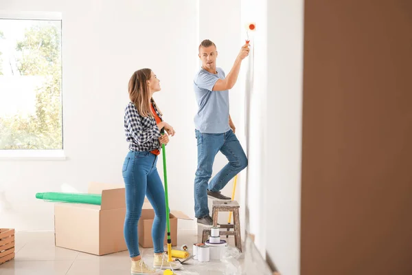 Feliz jovem casal fazendo reparação em sua nova casa — Fotografia de Stock