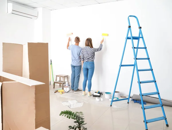 Feliz jovem casal fazendo reparação em sua nova casa — Fotografia de Stock