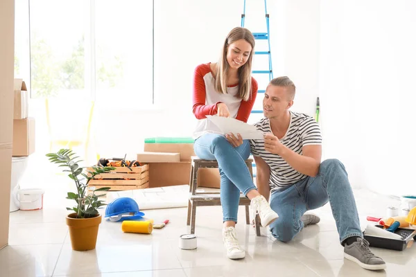 Feliz joven pareja eligiendo el color de las paredes en su nueva casa — Foto de Stock