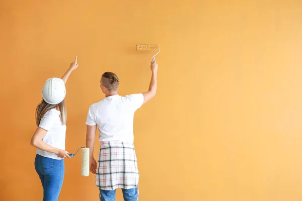 Feliz jovem casal parede pintura em sua nova casa — Fotografia de Stock