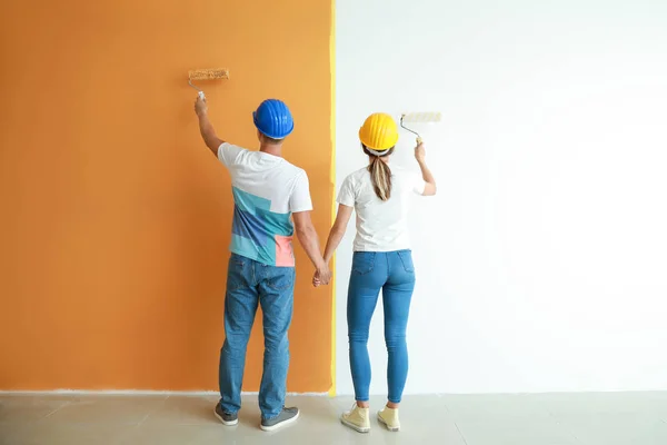 Feliz jovem casal parede pintura em sua nova casa — Fotografia de Stock