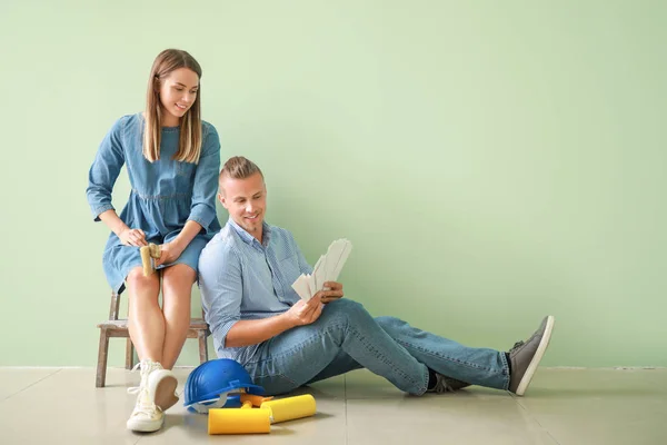 Happy young couple choosing color of walls in their new house — Stock Photo, Image