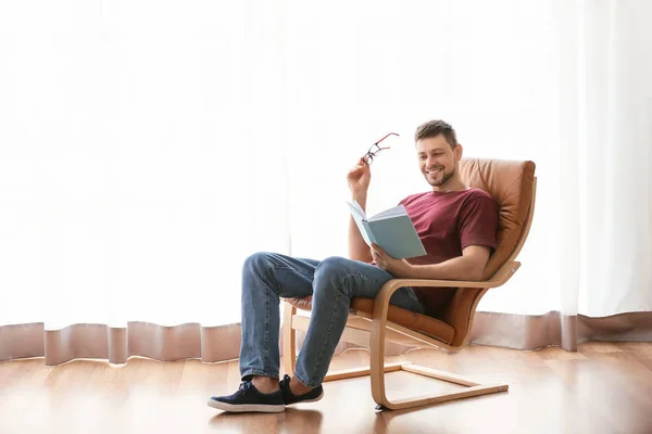 Homem com livro relaxante em casa — Fotografia de Stock