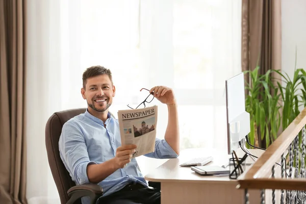 Homem lendo jornal durante o trabalho no escritório — Fotografia de Stock