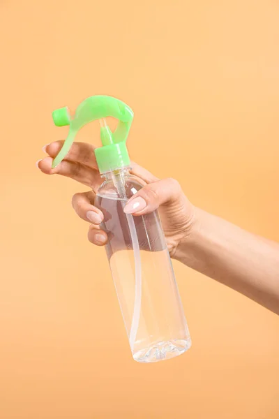色の背景に空気清浄剤のボトルを持つ女性の手 — ストック写真