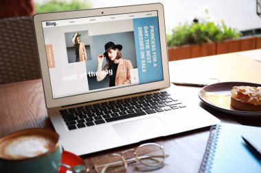Kafede masada moda blogun açık sayfa ile Laptop