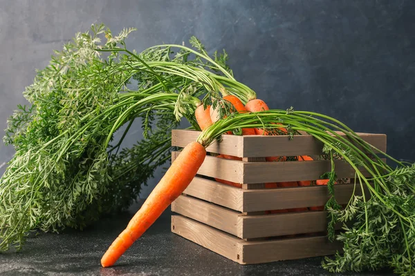 Wooden box with fresh carrots on table — Stock Photo, Image