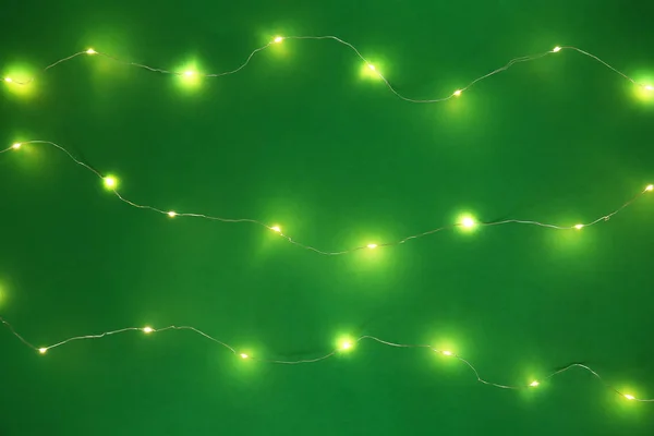 Hermosas luces de Navidad sobre fondo de color — Foto de Stock