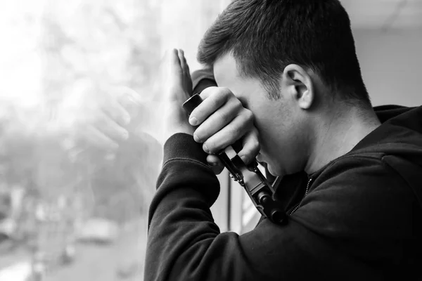 Photo en noir et blanc d'un jeune homme armé qui va se suicider près d'une fenêtre — Photo