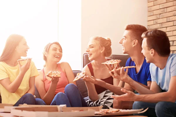 Unge mennesker som spiser deilig pizza hjemme – stockfoto