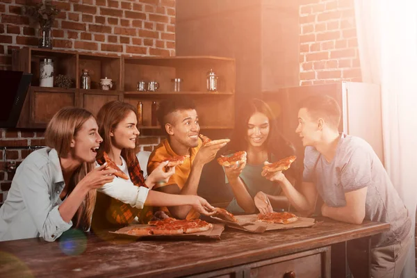 A fiatal emberek eszik finom pizzát otthon — Stock Fotó